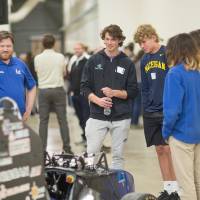 high school students interacting with laker racer cars